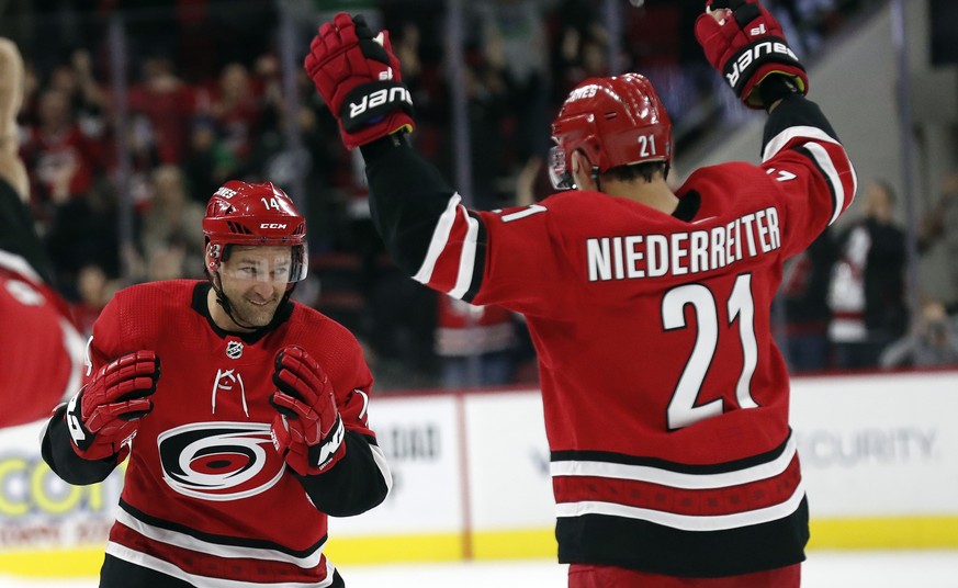 Carolina Hurricanes right wings Justin Williams, left, and Nino Niederreiter (21), of Switzerland, celebrate Williams&#039; winning goal in a shootout against the Vancouver Canucks during an NHL hocke ...