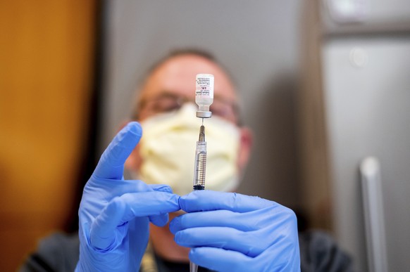 FILE - In this Jan. 12, 2021, file photo Pharmacist Brian Kiefer draws saline while preparing a dose of Pfizer&#039;s COVID-19 vaccine at UC Davis Health in Sacramento, Calif. With demand for the coro ...