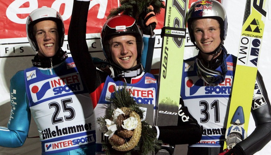 Andreas Kuettel of Switzerland (L) who finished in third place and Thomas Morgenstern of Austria (R) who finished in second place join with winner Simon Ammann of Switzerland (C) on the podium after t ...