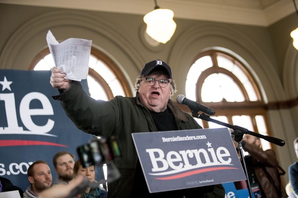 REMOVERS REFERENCE TO &quot;FORMER SENATOR&quot; Filmmaker Michael Moore holds up a list of what he says were cities where Democratic presidential candidate Sen. Bernie Sanders, I-Vt., campaigned for  ...