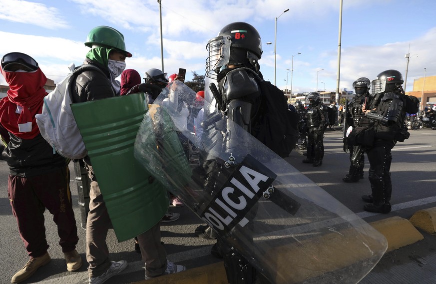 Police remove anti-government protesters from blocking a bus terminal in Bogota, Colombia, Tuesday, May 18, 2021. Colombians have taken to the streets for weeks across the country after the government ...