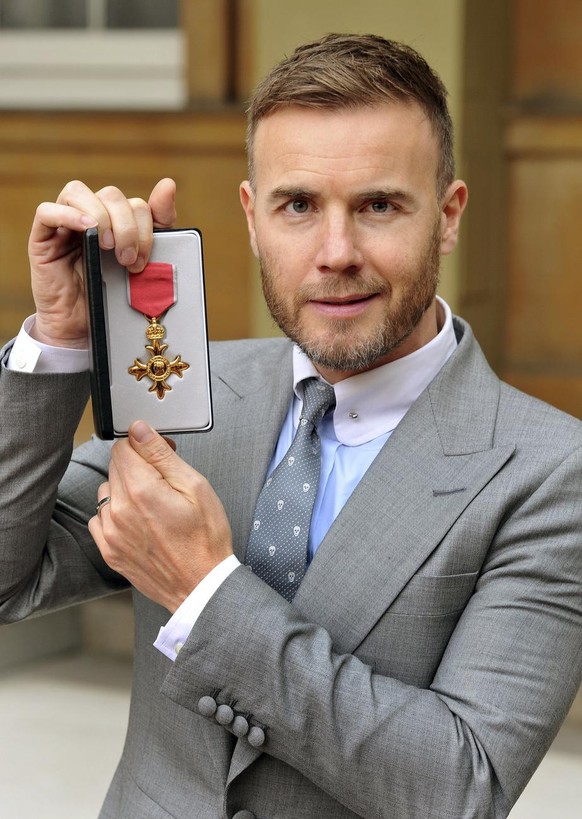 British musician Gary Barlow displays his OBE, for services to the entertainment industry and charity, which was awarded to him by Queen Elizabeth II, during an Investiture ceremony at Buckingham Pala ...
