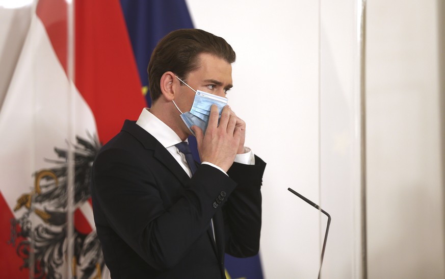 Austrian Chancellor Sebastian Kurz wearing a face mask to protect against coronavirus, stands behind behind a plexiglass shield prior to making an address, at the federal chancellery in Vienna, Austri ...