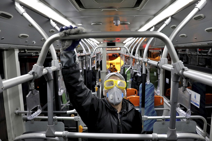 A worker disinfects a public bus against coronavirus in Tehran, Iran, in early morning of Wednesday, Feb. 26, 2020. Iran&#039;s government said Tuesday that more than a dozen people had died nationwid ...