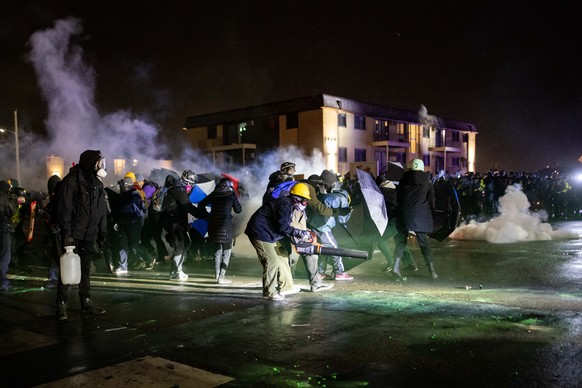epa09134247 Protesters clash with police in front of the Brooklyn Center Police station in Brooklyn Center, Minnesota, USA, 13 April 2021. For the third night in a row protesters faced off with local  ...