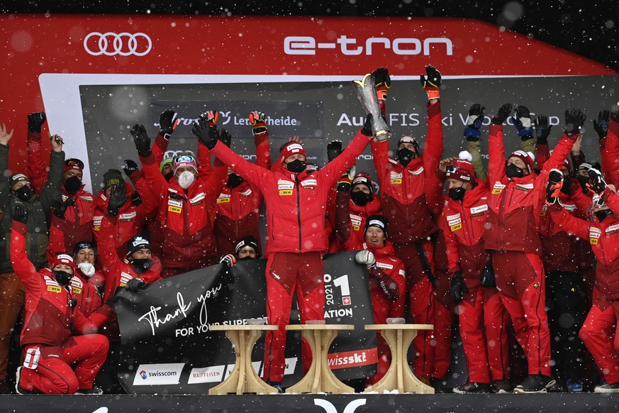 Urs Lehmann, president of the Swiss Ski team, center, celebrates with the trophy during the award ceremony of the nations cup competition at the FIS Alpine Skiing World Cup finals, in Lenzerheide, Swi ...
