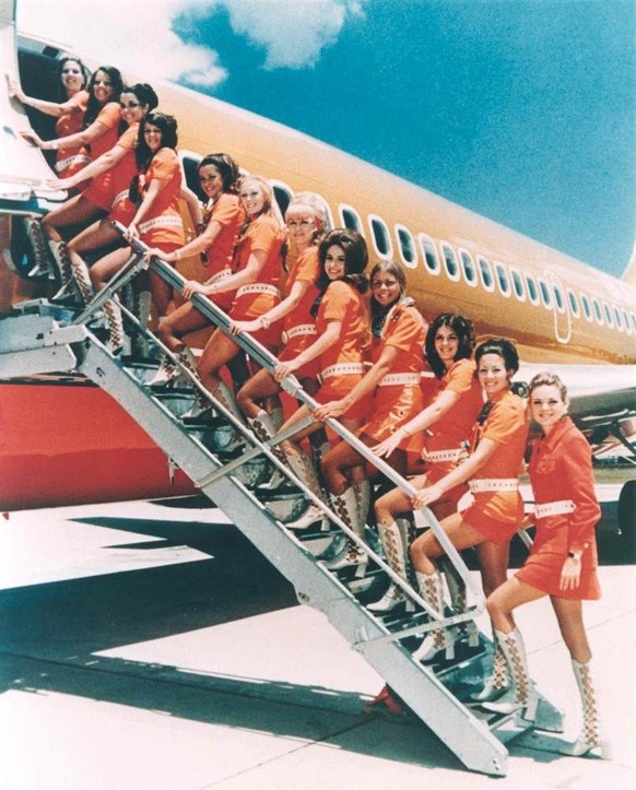 Eine Treppe voll orangefarbener, gestiefelter Sothwest Airlines Stewardessen.