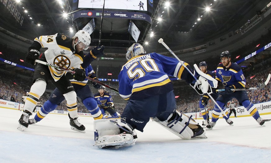 St. Louis Blues goaltender Jordan Binnington (50) catches the puck as Boston Bruins left wing Jake DeBrusk (74) watches for the rebound during the first period in Game 6 of the NHL hockey Stanley Cup  ...