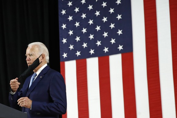 Democratic presidential candidate, former Vice President Joe Biden removes a face mask to protect against the spread of the new coronavirus as he arrives to speak at Alexis Dupont High School in Wilmi ...