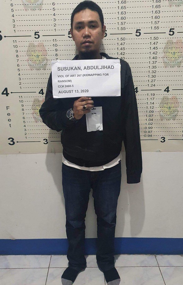 In this photo provided by the Philippine National Police-Public Information Office, Abu Sayyaf commander Anduljihad Susukan poses for a picture at the Davao City Police Station in Davao province, sout ...