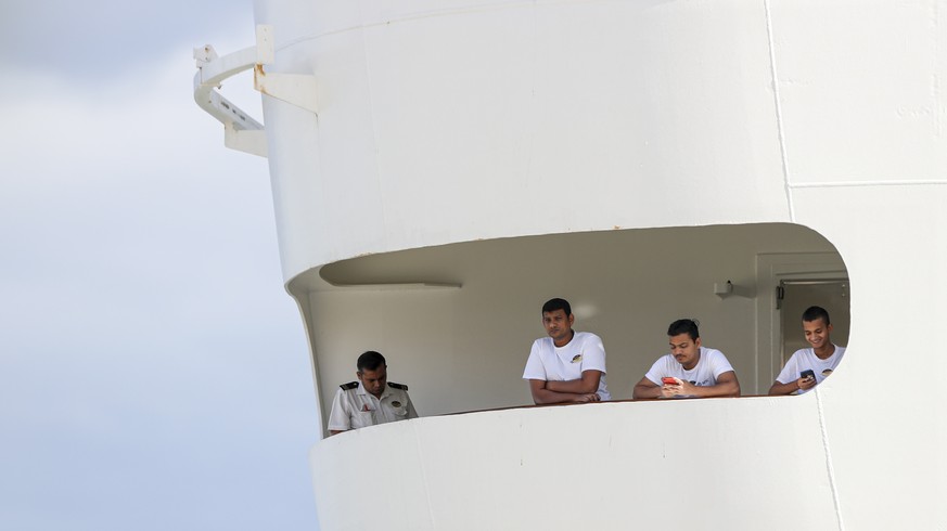 epa08313816 Crew members observe from windows of the cruise ship &#039;MSC Fantasia&#039;, that travelled from Brazil to Portugal with 1338 passengers on board, of 38 nationalities at the Lisbon Harbo ...