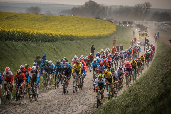 epa08301573 (FILE) - The riders pack in action on a cobblestone section during the 117th Paris Roubaix cycling race, France, 14 April 2019 (reissued on 17 March 2020). On 17 March 2020 the organisers  ...