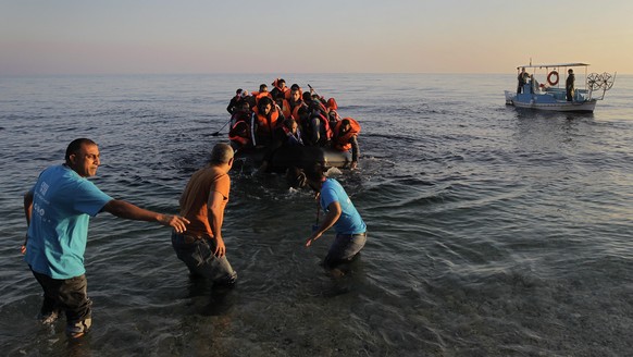 epa05047177 epa05025297 Local fishermen assist refugees arriving with a rubber dinghy on the Greek island of Lesbos (Lesvos), Greece, 14 November 2015, after crossing the Aegean Sea from Turkey. Greec ...