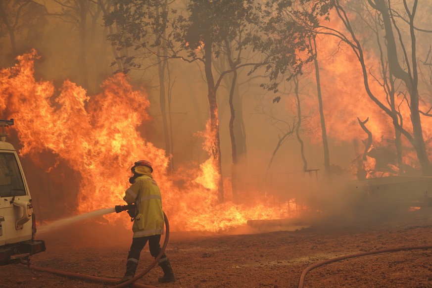 epa08983284 A handout photo made available on 03 February 2021 by Australia&#039;s Department of Fire and Emergency Services (DFES) shows firefighters battling the Wooroloo Bushfire, north-west of Per ...