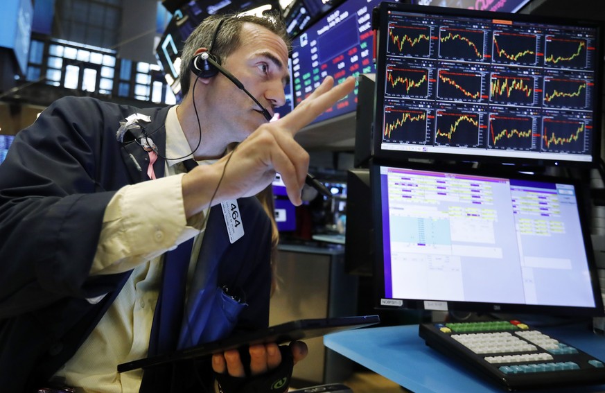 FILE - In this July 30, 2019 file photo, trader Gregory Rowe works on the floor of the New York Stock Exchange. An economic alarm bell is sounding in the U.S. and sending warnings of a potential reces ...