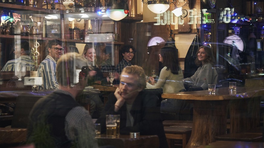 FILE - People sit in a bar in Stockholm, Sweden, Wednesday, March 25, 2020. The streets of Stockholm are quiet but not deserted. People still sit at outdoor cafes in the center of Sweden&#039;s capita ...