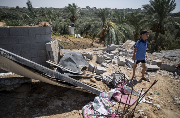 A Palestinian boy inspects the damage in his family home following Israeli airstrikes in Buriej refugee camp, central Gaza Strip, Saturday, Aug. 15, 2020. (AP Photo/Khalil Hamra)