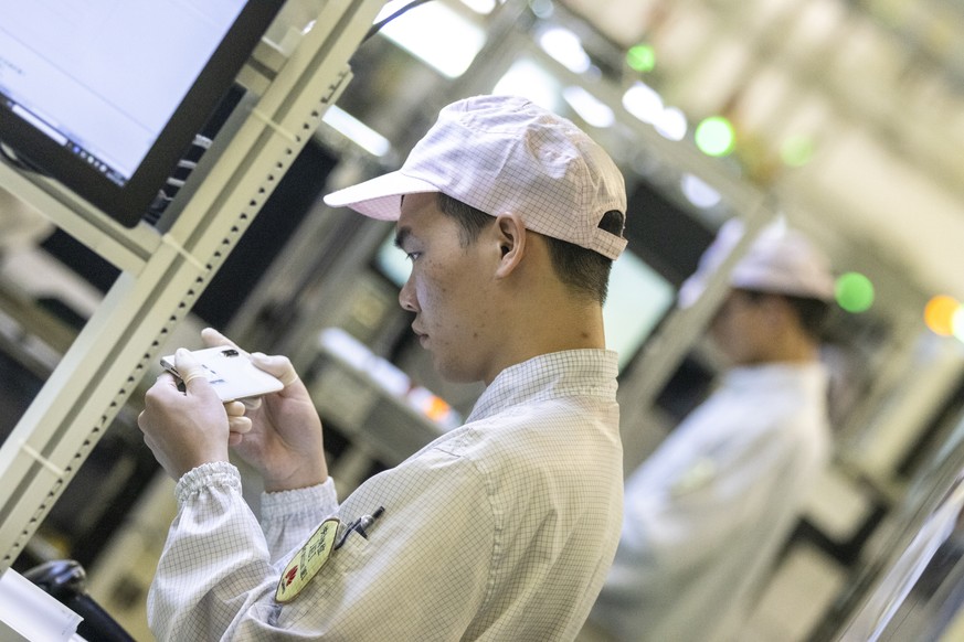epa08064339 A man works at a smartphone line at a Huawei factory in Dongguan, Guangdong Province, China, 10 December 2019 (issued 12 December 2019). Huawei founder and CEO Ren Zhengfei said on 11 Dece ...