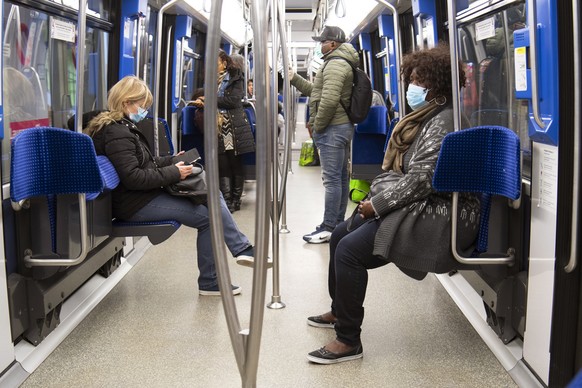 epaselect epa08315790 People wearing protective face masks ride the TL Metro M2 underground amid the coronavirus COVID-19 pandemic in Lausanne, Switzerland, 23 March 2020. The Swiss authorities procla ...