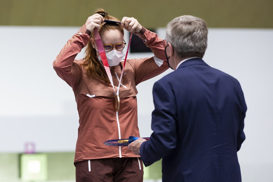 Thomas Bach, president of the International Olympic Committee, hands over the bronze medal to Nina Christen of Switzerland after the women&#039;s shooting 10m air rifle final at the 2020 Tokyo Summer  ...