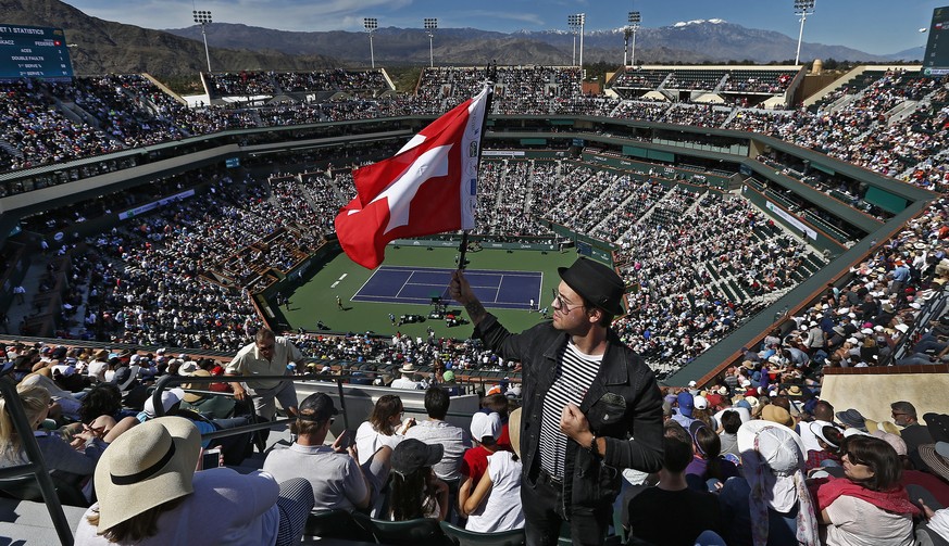 epa07440662 A fan poses with the Swiss flag during the Roger Federer of Switzerland match against Hubert Hurkacz of Poland during the BNP Paribas Open tennis tournament at the Indian Wells Tennis Gard ...