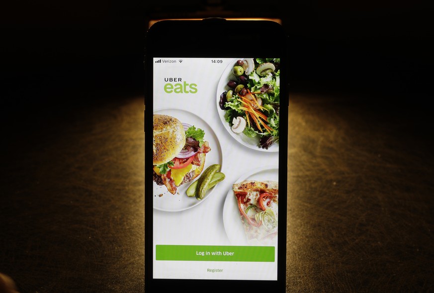 FILE - In this Feb. 20, 2018, file photo shows the Uber Eats app on an iPhone in Chicago. Uber is testing restaurant food deliveries by drone. The company&#039;s Uber Eats unit began the tests in San  ...