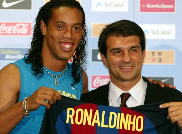 Brazilian soccer player Ronaldo de Assis Morerira, &quot;Ronaldinho&quot;, left, shows off his new Barcelona jersey with club president Joan Laporta in Barcelona, Spain,. Monday, July 21, 2003. (KEYST ...