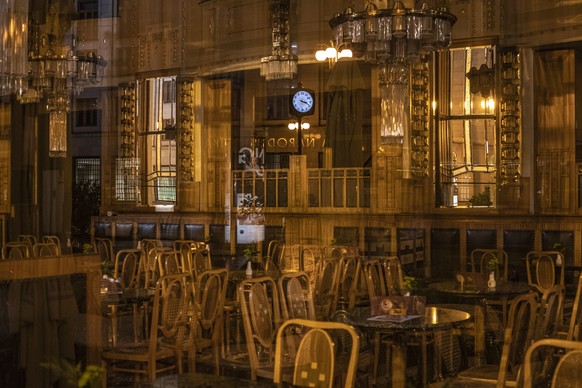 epa08741874 A street clock is reflected in the mirror behind empty tables and chairs in closed restaurant at Municipal House in Prague, Czech Republic, 13 October 2020. Czech government decided from 1 ...