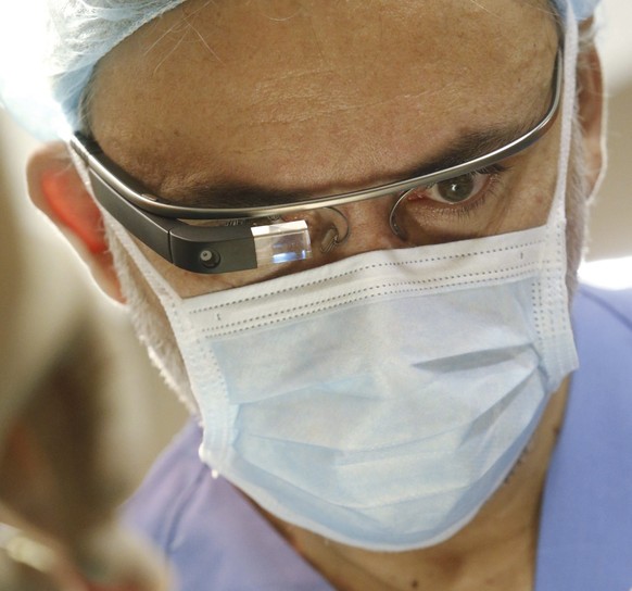 epa03925268 Spanish dentist surgeon Pedro Pena carries out a maxillofacial surgery while broadcasting live with the new &#039;google glass&#039; at the Molina de Segura hospital in Murcia, Spain, 26 O ...