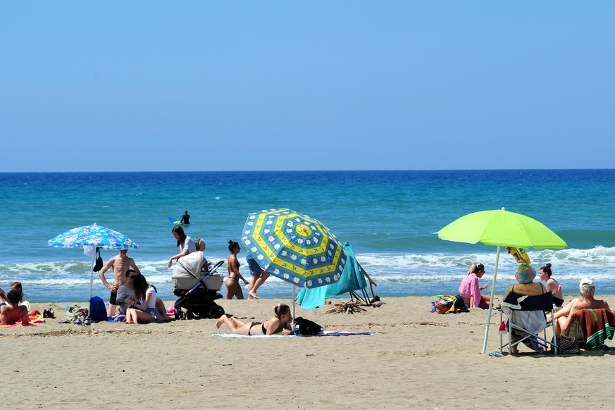 People enjoy a sunny day at the beach in Tuscany&#039;s Castiglione della Pescaia, Italy, Sunday, May 24, 2020. Europeans and Americans soaked up the sun where they could, taking advantage of the firs ...
