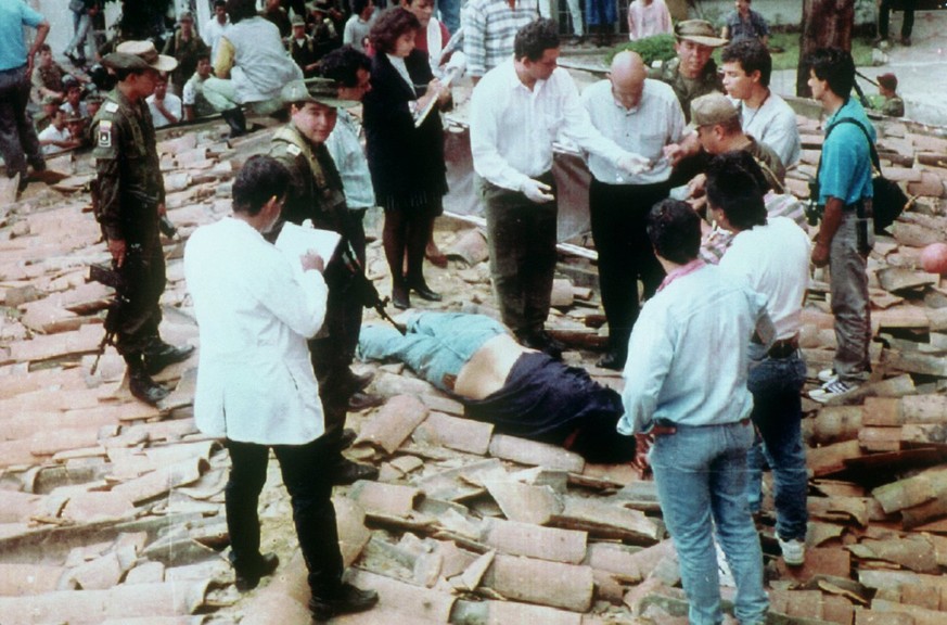 Polizeibeamte und Journalisten umringen die am Boden liegende Leiche des kolumbianischen Drogenbosses Pablo Escobar. Escobar ist am 2. Dezember 1993 waehrend einer Polizeiaktion erschossen worden. Er  ...