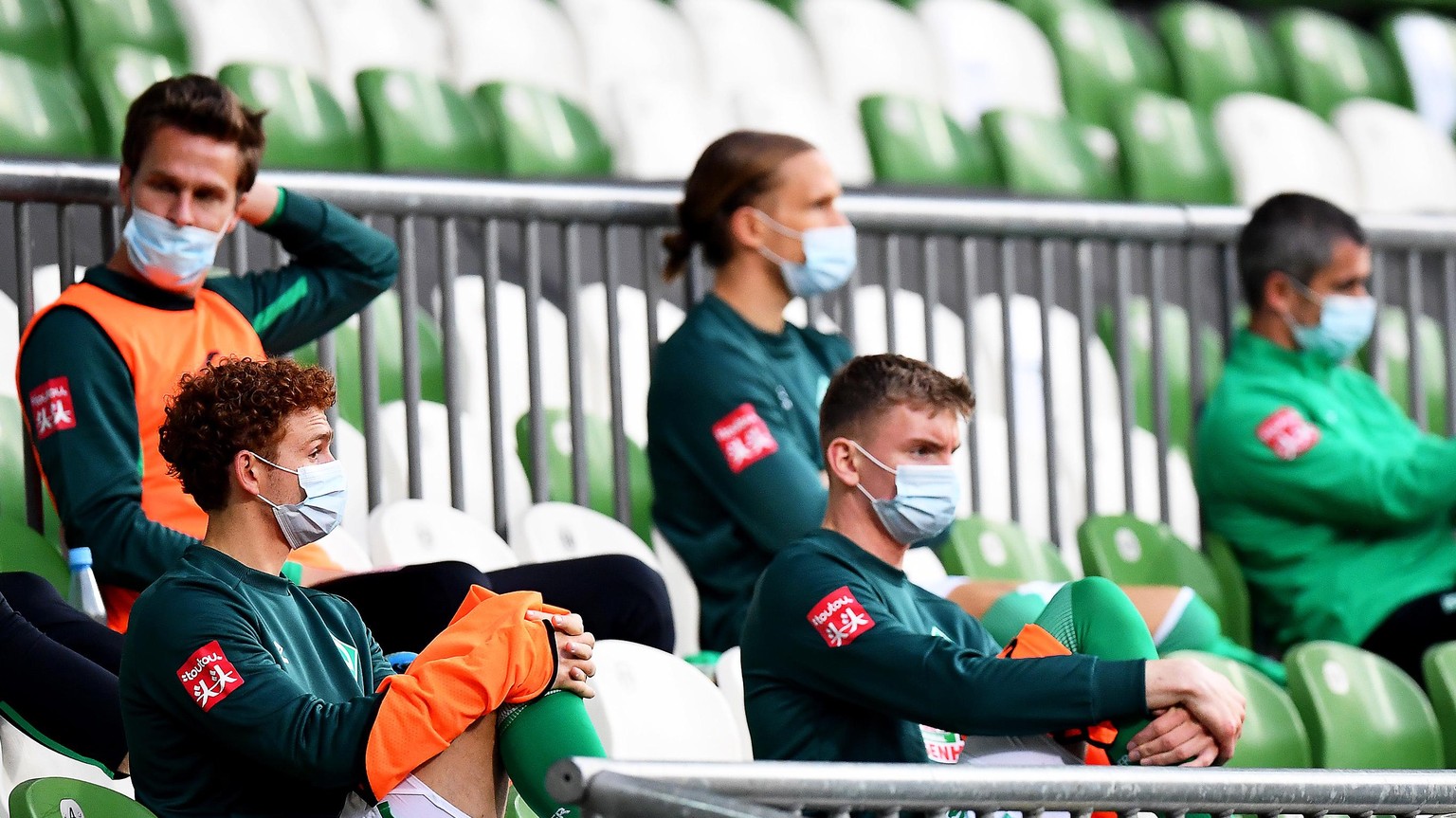 epa08430815 Players of Werder Bremen wearing protective face masks sit on the bench during the German Bundesliga soccer match between SV Werder Bremen and Bayer 04 Leverkusen in Bremen, Germany, 18 Ma ...