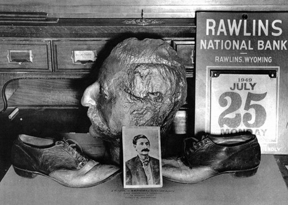 Death mask of Big Nose George Parrott and shoes made from his skin, on display at the Rawlins National Bank, 1949. Historical Reproductions by Perue.