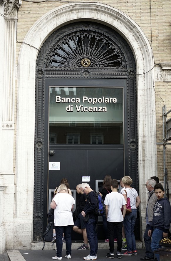 People queue outside a &quot;Banca Popolare di Vicenza&quot; bank branch in Rome, Sunday, Oct. 26, 2014. The European Central Bank says 13 of Europe&#039;s 130 biggest banks have flunked an in-depth r ...