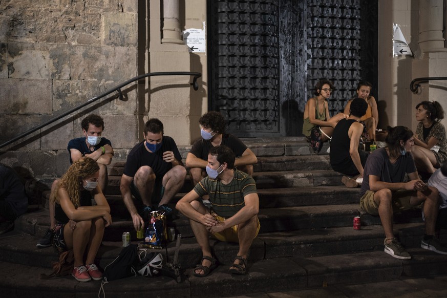 People gather at a public square at night in Gracia neighborhood, Barcelona, Spain, Friday, July 24, 2020. Health authorities in the northeastern region of Catalonia have ordered nightclubs to be full ...