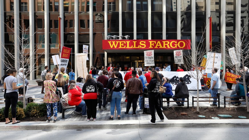 Protesters rally outside the Wells Fargo bank downtown branch Tuesday, April 24, 2018, in Des Moines, Iowa. In a settlement announced last week, Wells Fargo will pay $1 billion to federal regulators t ...