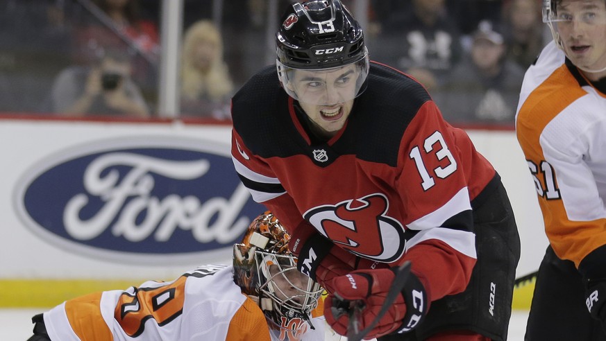 Philadelphia Flyers goaltender Carter Hart, left, and New Jersey Devils&#039; Nico Hischier watch the puck during the second period of an NHL hockey game in Newark, N.J., Friday, Nov. 1, 2019. (AP Pho ...