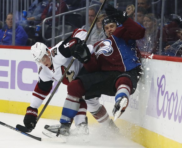Arizona Coyotes defenseman Connor Murphy, left, checks Colorado Avalanche right wing Mikko Rantanen, of Finland, against the boards during the third period of an NHL hockey game Tuesday, Nov. 8, 2016, ...