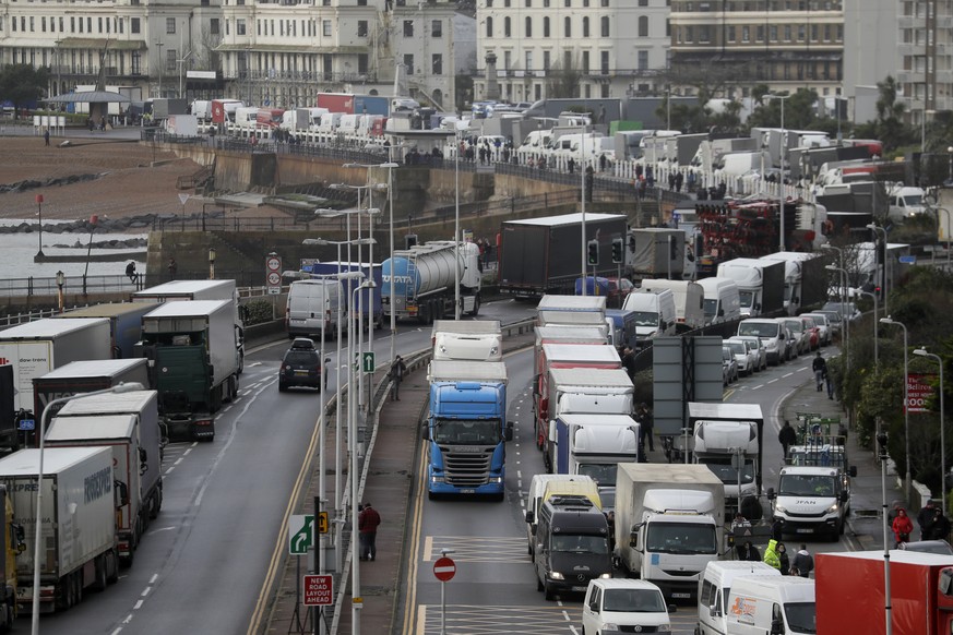 Trucks parked on the roadside whilst the Port remains closed, in Dover, southern England, Tuesday, Dec. 22, 2020. Trucks waiting to get out of Britain backed up for miles and people were left stranded ...