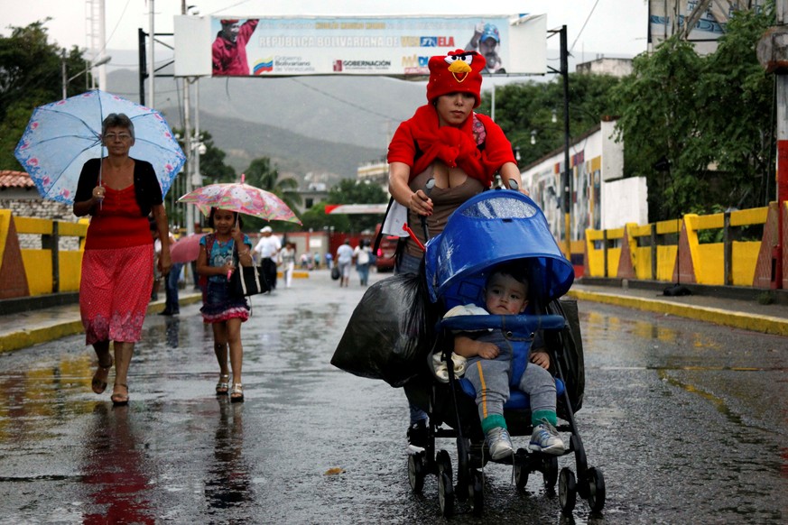 A woman push a pram with a baby and bags as she crosses the Colombian-Venezuelan border over the Simon Bolivar international bridge after shopping, in San Antonio del Tachira, Venezuela, July 16, 2016 ...