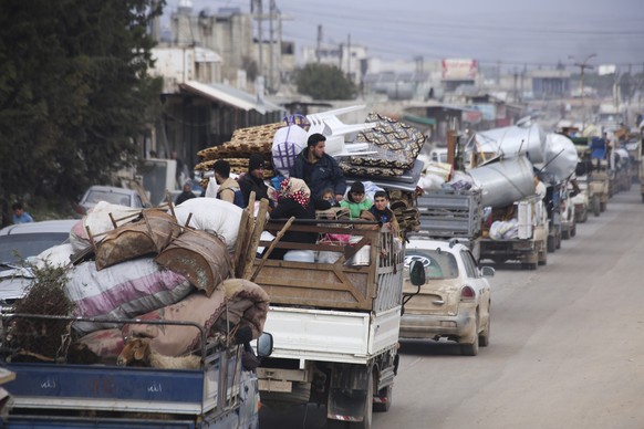 Syrian refugees head northwest through the town of Hazano in Idlib province as the flee renewed fighting Monday, Jan. 27, 2020. (AP Photo/Ghaith Alsayed)