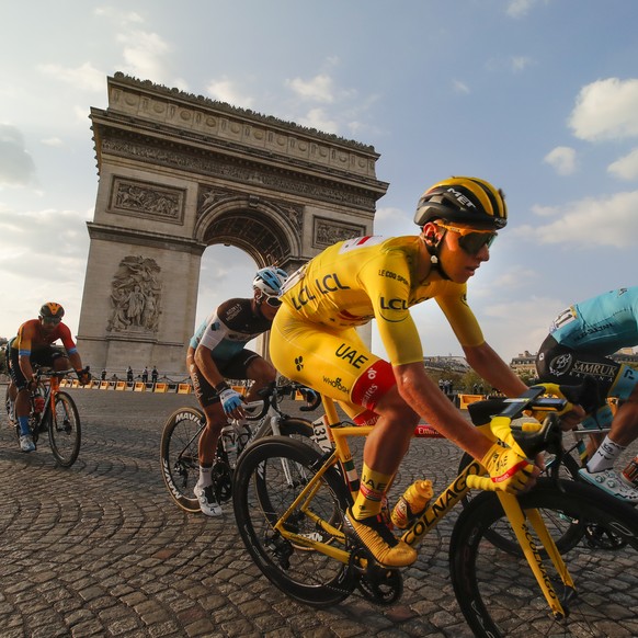 Slovenia&#039;s Tadej Pogacar, wearing the overall leader&#039;s yellow jersey, rides past the Arc de Triomphe on the Champs-Elysees during the twenty-first and last stage of the Tour de France cyclin ...