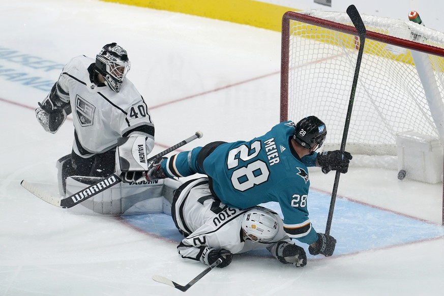 Los Angeles Kings goaltender Calvin Petersen (40), left wing Andreas Athanasiou, bottom, and San Jose Sharks right wing Timo Meier (28) watch the puck on a goal scored by Tomas Hertl during the third  ...
