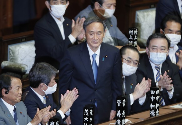 epa08672010 Yoshihide Suga (C) is applauded by his colleagues after being elected as new Japanese Prime Minister at an extraordinary parliametary session in Tokyo, Japan, 16 September 2020. Suga succe ...