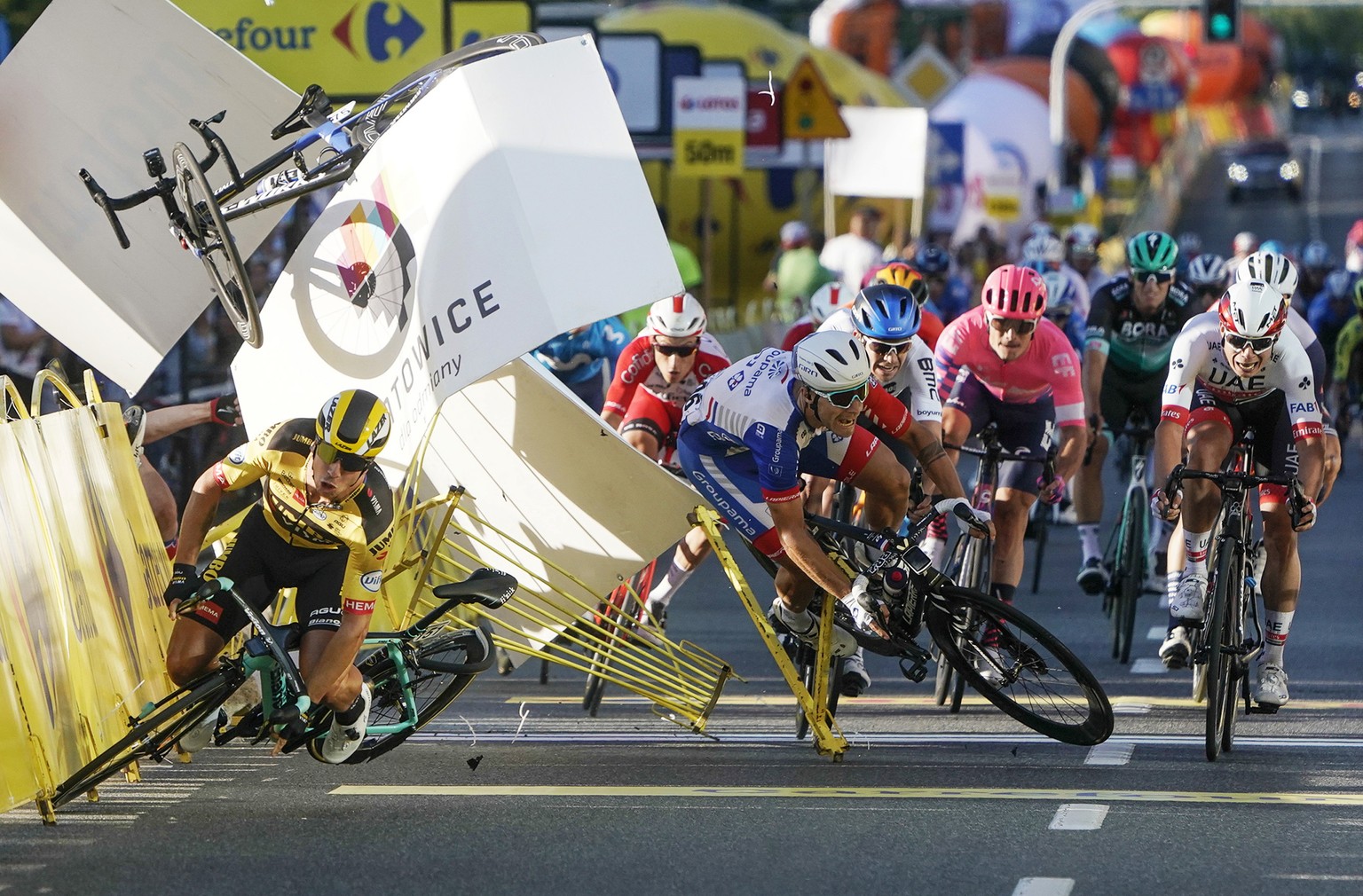 Dutch cyclist Dylan Groenewegen crashes to the ground as a bicycle is flying overhead in a major collision on the final stretch of the opening stage of the Tour de Pologne race in Katowice, Poland, We ...