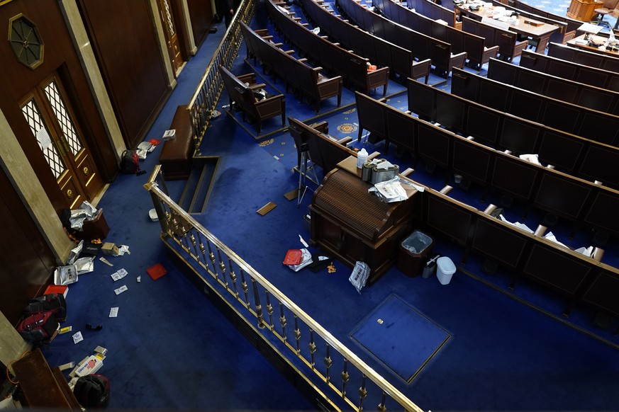 Papers and other materials litter the chamber after House were evacuated as protesters try to break into the House Chamber at the U.S. Capitol on Wednesday, Jan. 6, 2021, in Washington. (AP Photo/Andr ...