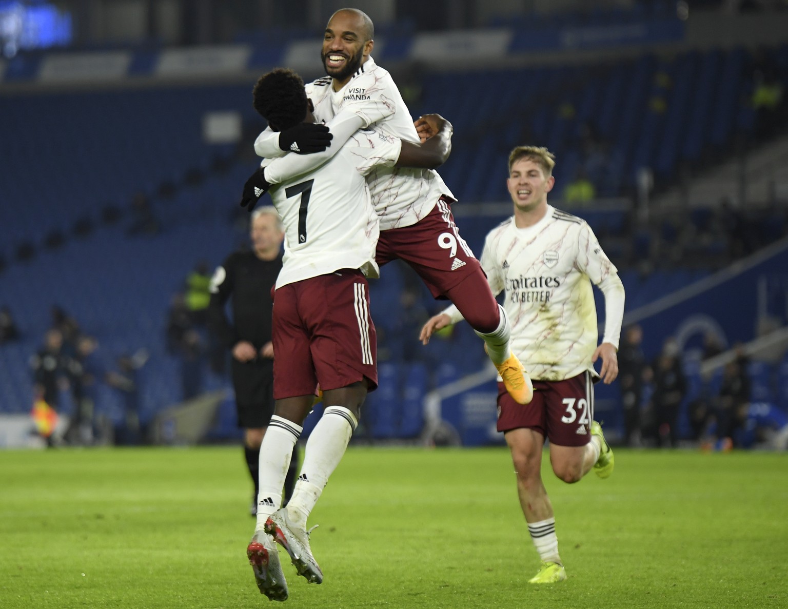 epa08910139 Alexandre Lacazette (C) of Arsenal celebrates with teammate Bukayo Saka (L) after scoring opening goal during the English Premier League soccer match between Brighton &amp; Hove Albion FC  ...