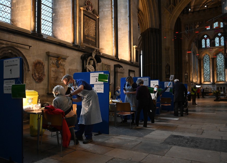 epa08951814 Doctors administer the Pfizer-BioNTech vaccine at a vaccination centre in Salisbury Cathedral in Salisbury, Britain, 20 January 2021. More than four million people in the UK have received  ...