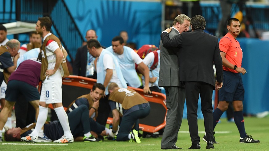 MANAUS, BRAZIL - JUNE 14: England manager Roy Hodgson speaks to head coach Cesare Prandelli of Italy as England trainer Gary Lewin lies on the ground being treated for an injury during the 2014 FIFA W ...