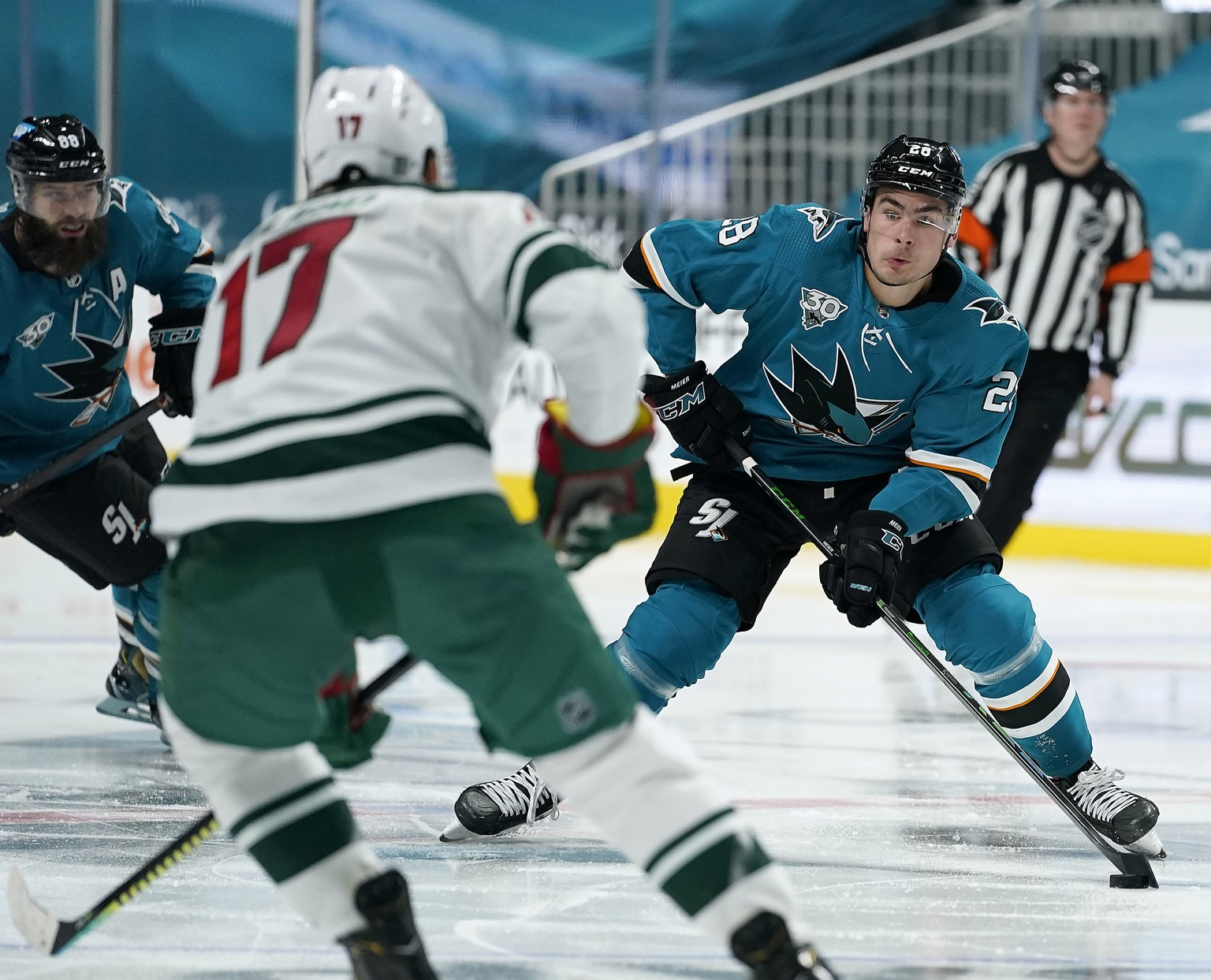San Jose Sharks right wing Timo Meier (28) looks to pass the puck down the ice against Minnesota Wild left wing Marcus Foligno (17) during the third period of an NHL hockey game in San Jose, Calif., M ...
